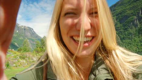 glückliche frau macht ein selfie in einer fjordlandschaft