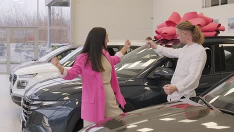 una hermosa pareja de jóvenes en la sala de exposición de automóviles eligiendo un coche nuevo para comprar.