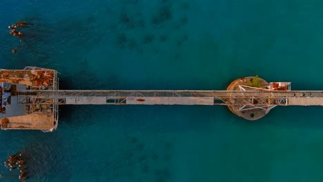 complete top view sliding right drone shot of a sugar cane pier located in aguadilla, puerto rico