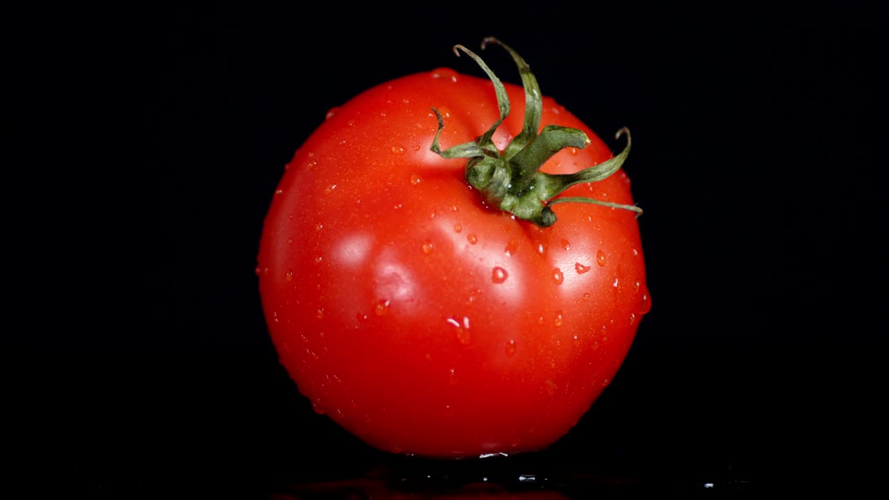 한 개의 신선한 토마토는 천천히 회전합니다.