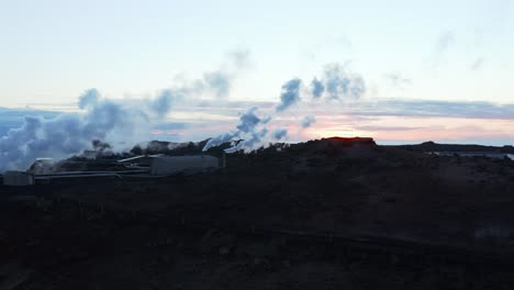 geothermal steam rising from electricity power plant in iceland during sunset, aerial