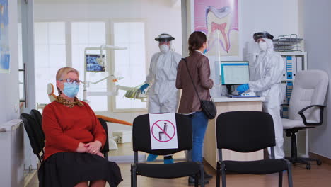 Médico-Dentista-Con-Traje-Protector-Trabajando-En-Una-Clínica-Estomatológica-Ocupada