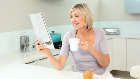 Mujer-Rubia-Leyendo-El-Periódico-Y-Tomando-Café.