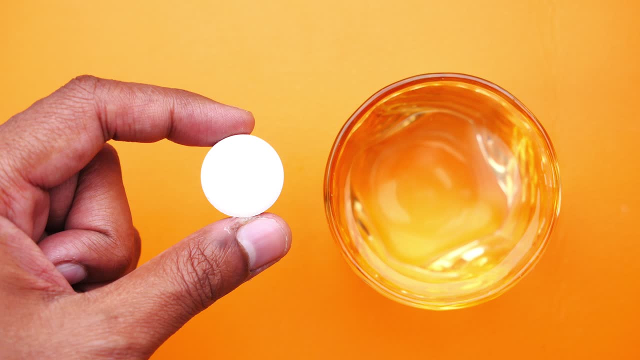 물 한 잔 위 에 약 을 들고 있는 사람