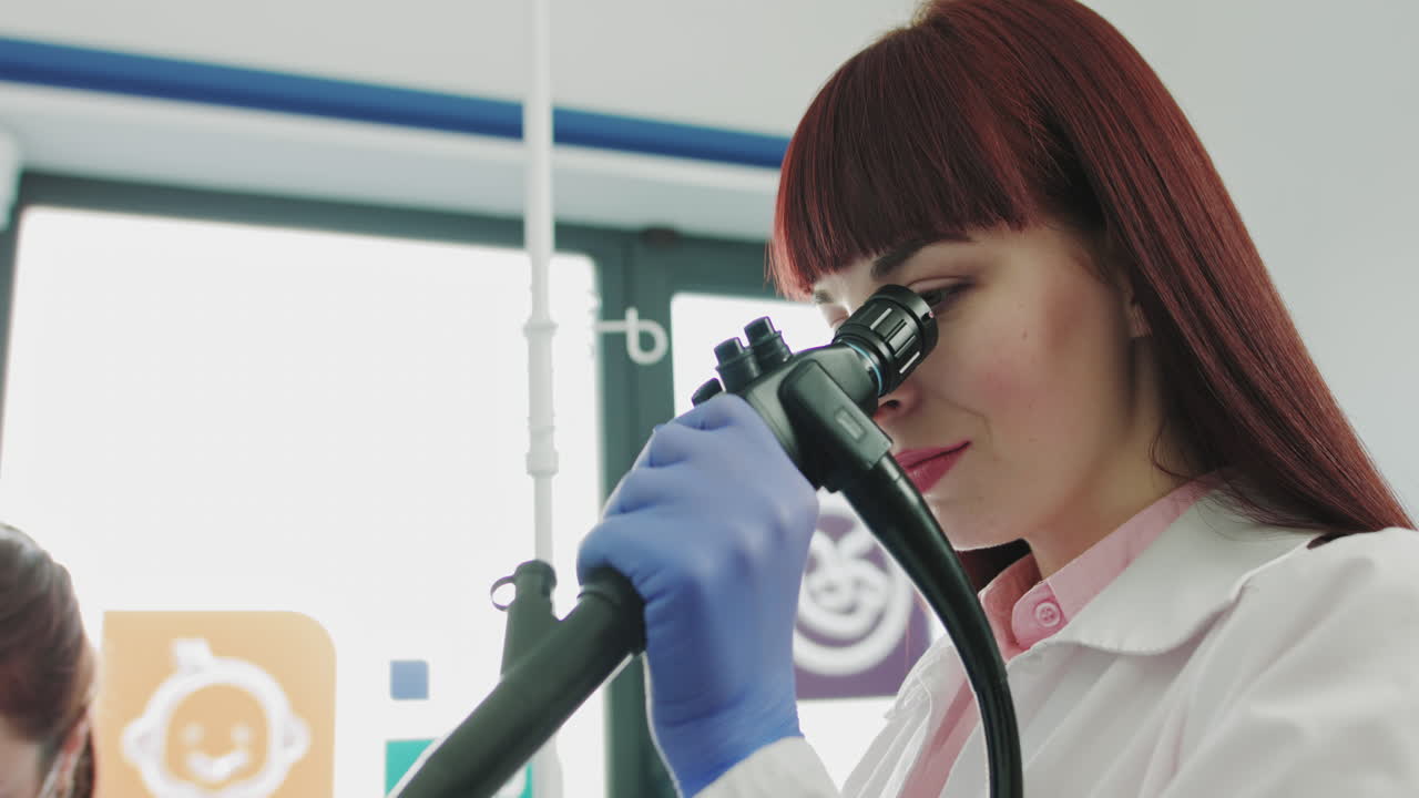 Surgeon looking into the microscope a female patient at the operating room doctor using microscope