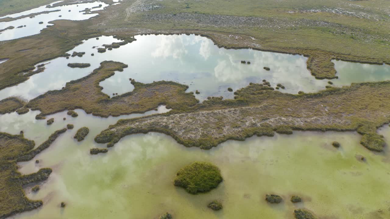 Aerial view of the Mezquites River on the Mexican desert of Cuatro Cienegas in Coahuila. RAMSAR protected area. Sky with clouds reflected on water.