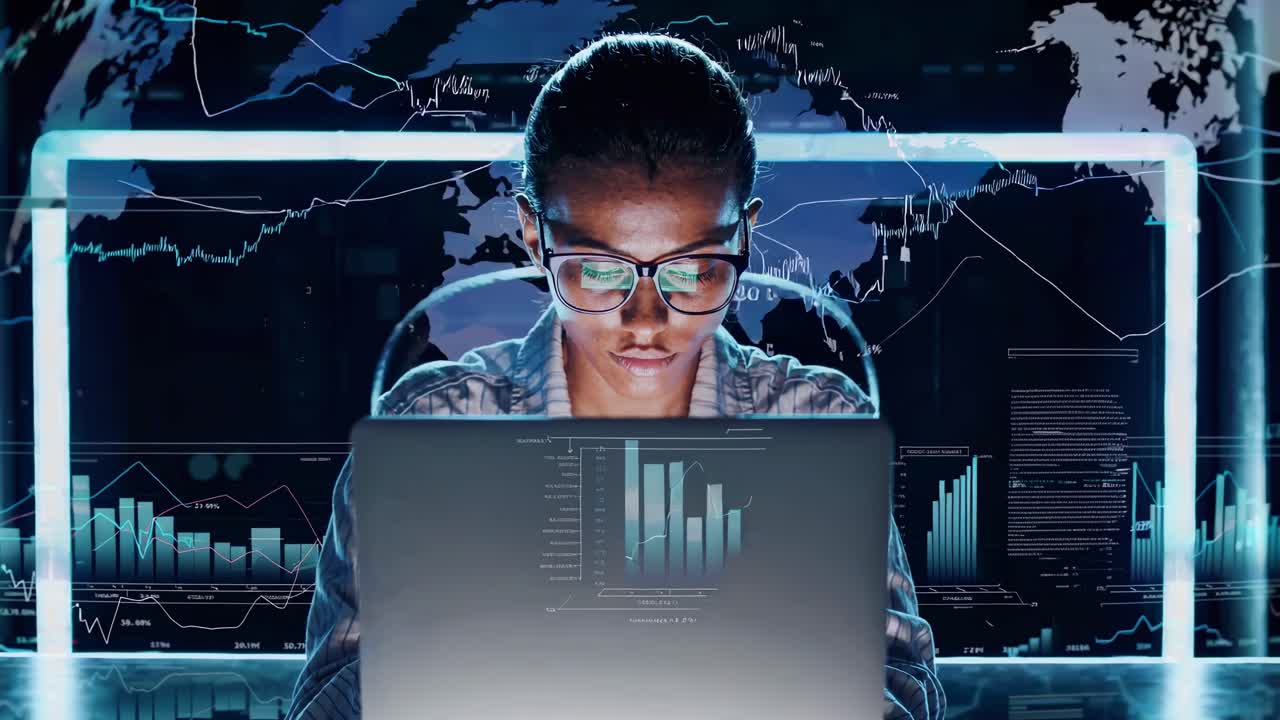 Luftfoto af en person ved en bærbar computer med digitale grafer overlejret, der skaber et futuristisk videokoncept