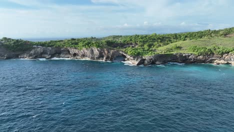 turquoise water bay with archway that wraps around the bay allowing water to flow in and out from the ocean