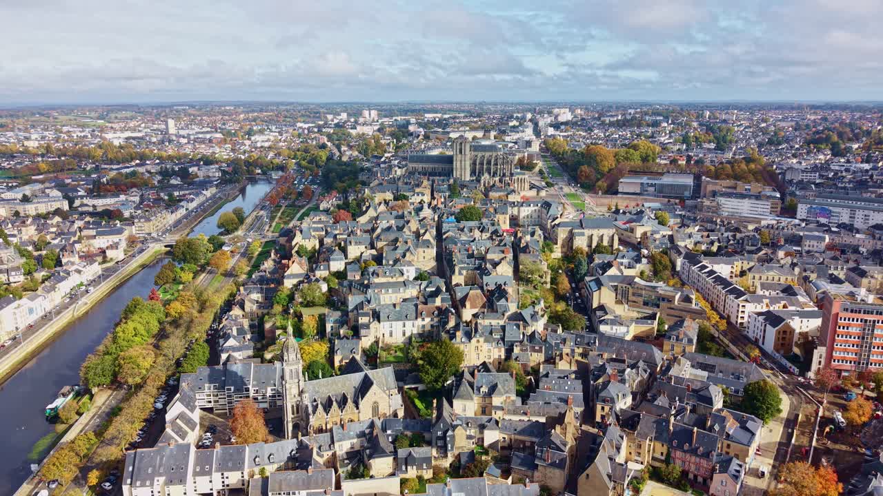 Aerial drone pan over Le Mans cityscape, sweeping across Cathédrale Saint-Julien and the old town rooftops tracing the meandering Sarthe River through a patchwork of rooftops and tree-lined avenues