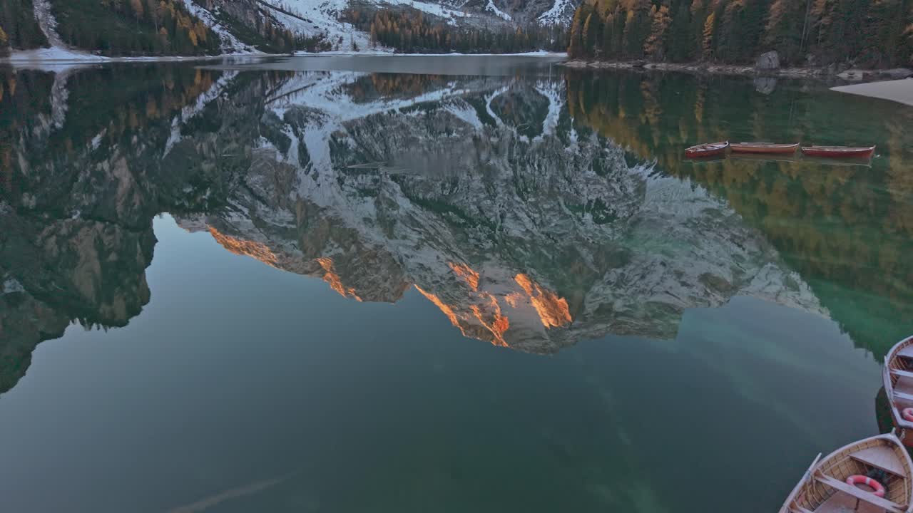 Lago di Braies in autumn with reflection and forest, drone perspective