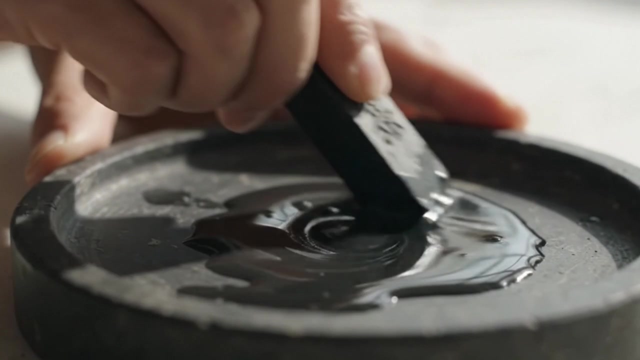 Kunstner river blækstang på en sten-blæksten til kalligrafi