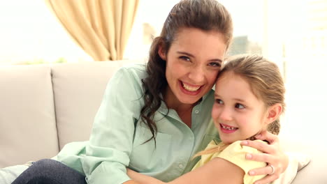 madre y hija felices en el sofá