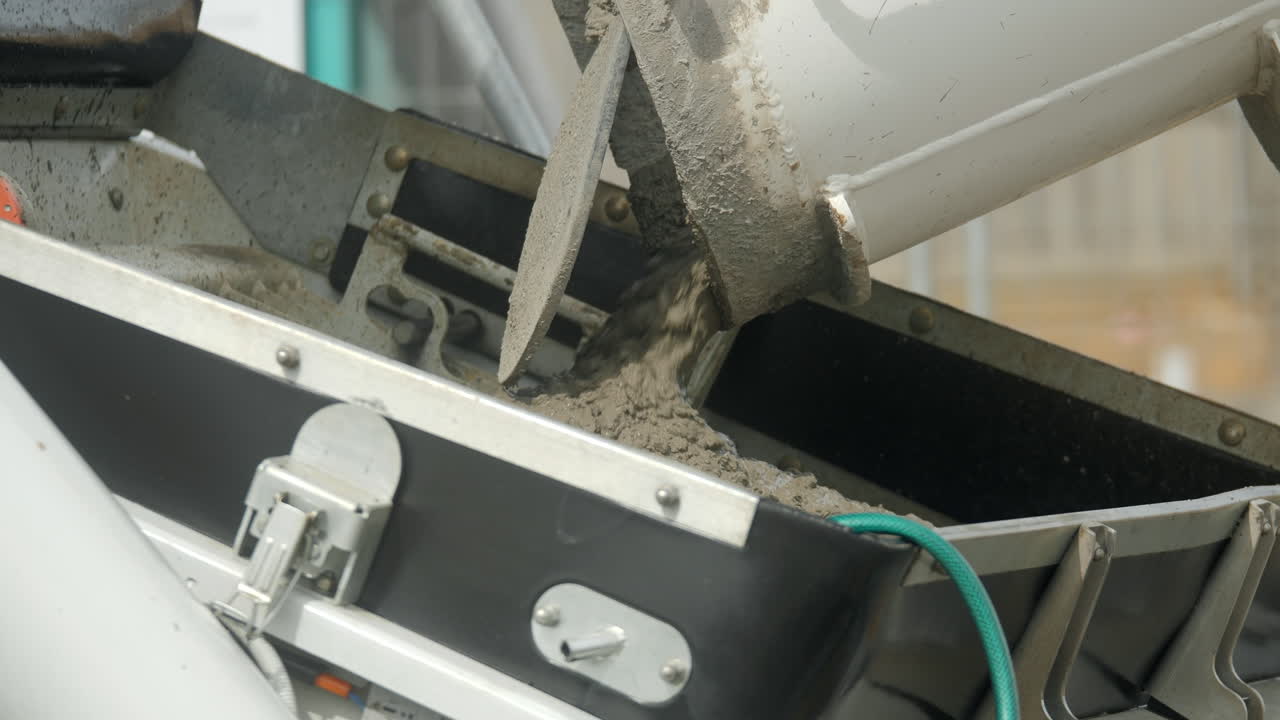 concreto en cámara lenta transferido del camión de cemento a la máquina de bombeo de concreto