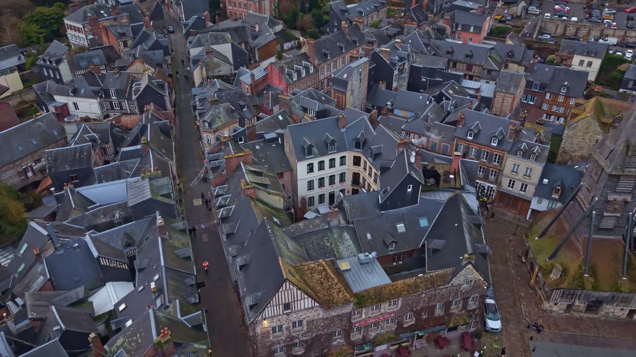 Vista drone delle strette vie e dei tetti in ardesia del centro storico di Honfleur, Francia. Ripresa aerea dall'alto in avanti.