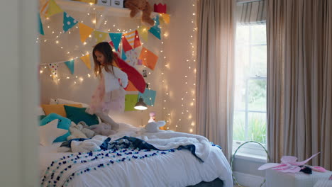 happy-little-girl-jumping-on-bed-wearing-costume-playing-game-enjoying-playful-imagination-in-colorful-bedroom-at-home