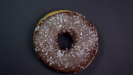 saboroso y fresco rosquilla rosquilla macro disparo de primer plano girando sobre un fondo negro.