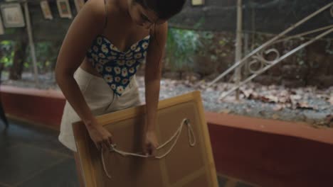 en un hipnótico clip de detalle en cámara lenta de las manos meticulosas de una joven preparan una cuerda de pintura con gracia y precisión, mejorando el ambiente de una galería de arte