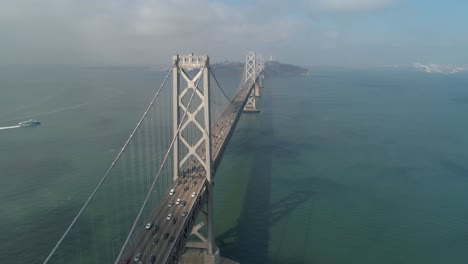 在舊金山-奧克蘭灣橋上移動的車輛的空中拍攝,背景是城市