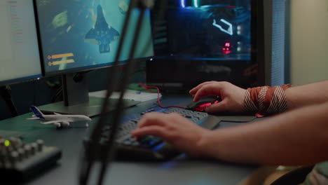 primer plano de las manos del jugador usando el teclado rgb en el estudio doméstico de juegos