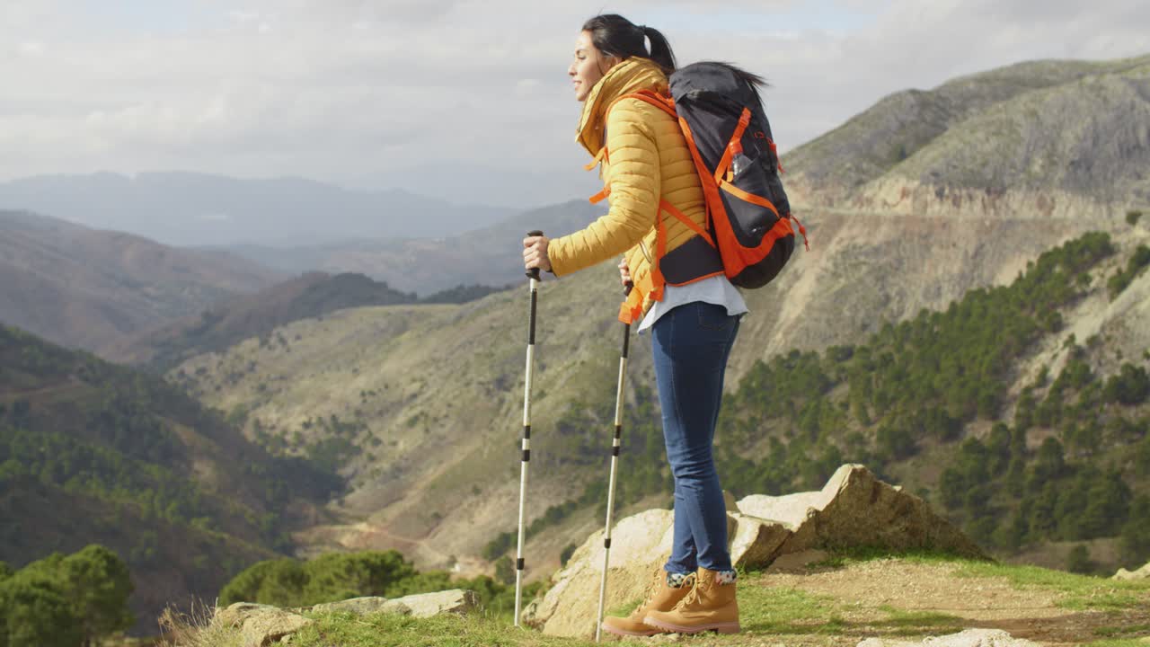 joven excursionista de pie con vistas a un valle