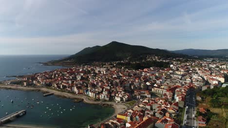 Aerial-view-of-a-sailing-boat-moored-along-the-coast-in-A-Guarda,-Spain