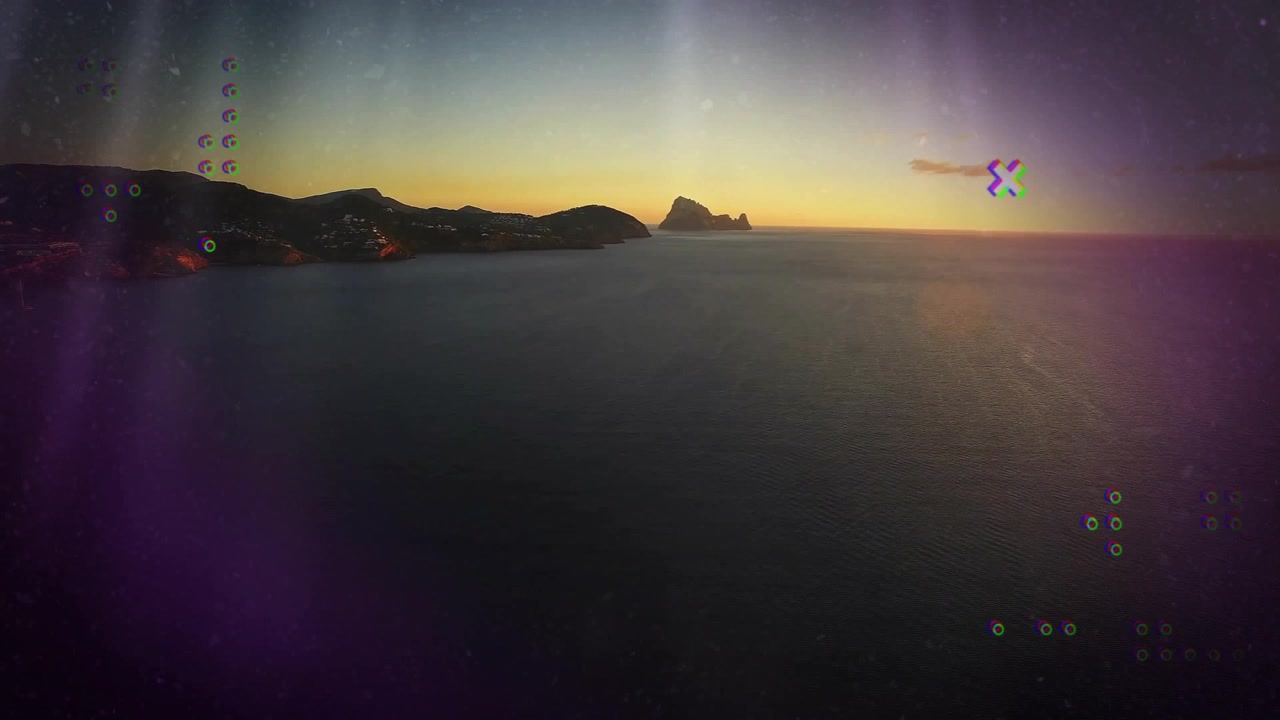 No início, sobreposições surgem, girando, com falhas e desaparecendo, exibindo um efeito de glitch em um crepúsculo costeiro.