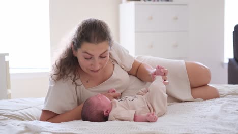 a mother bonding with her newborn baby on a bed