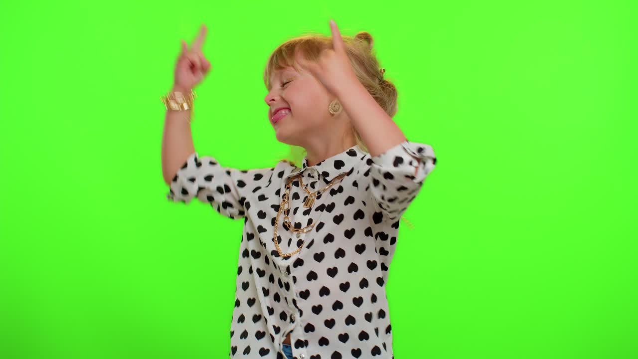 Overjoyed kid showing rock n roll gesture by hands, cool sign, dancing rejoicing in success win
