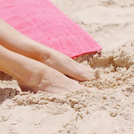 cerrar los pies de la mujer descansando sobre la arena de la playa