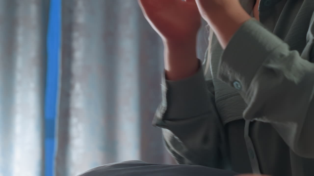 Close up of children engaging in playful hand game indoors, showing bonding and interaction through subtle gestures and movement in soft light setting with casual clothing and calm background