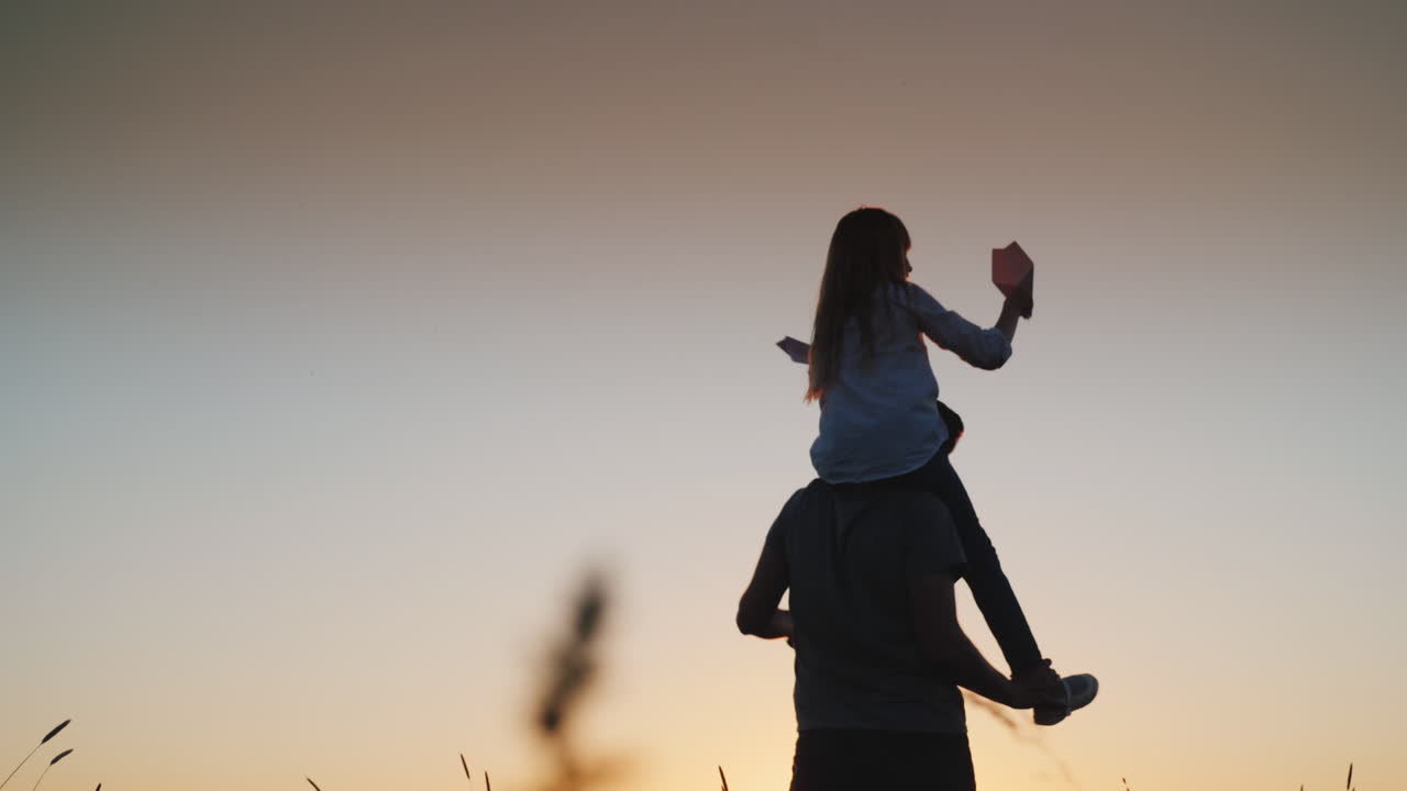 Padre felice che gioca con sua figlia al tramonto