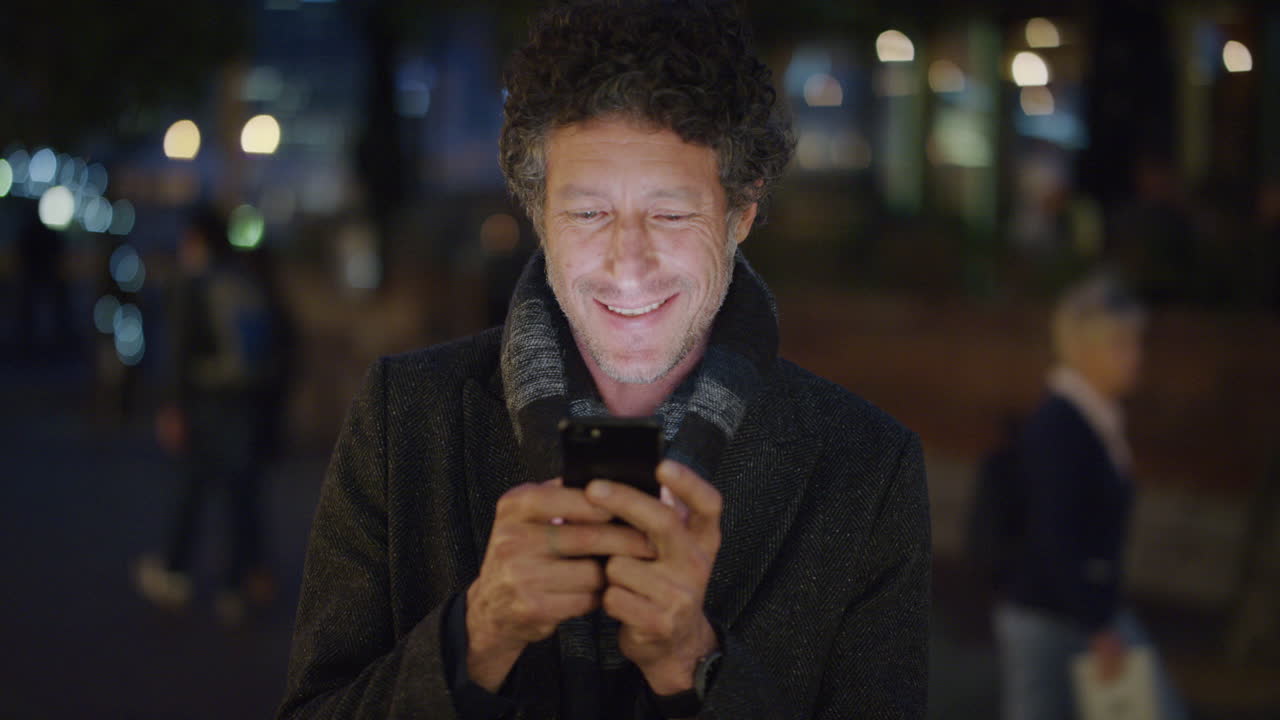 ritratto bel turista maturo che usa lo smartphone messaggistica che si gode la navigazione online che invia messaggi sms sul cellulare slow motion