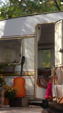 mujer explorando una caravana vintage en otoño