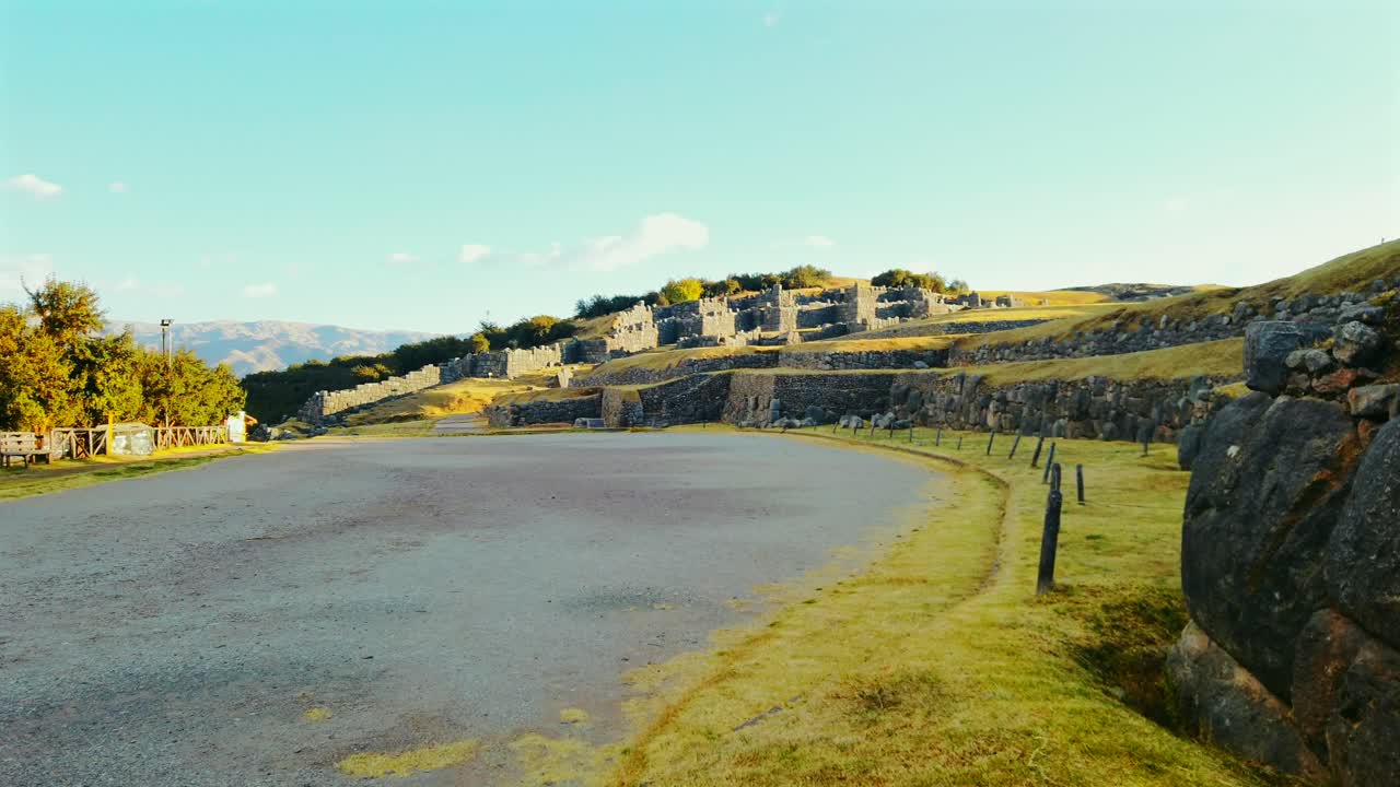 Unique and breathtaking view of Sacsayhuamán ruins with golden sunlight near Cusco, Peru. No tourists visiting, cinematic shot