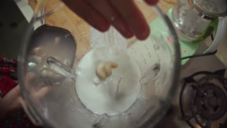 Woman-puts-soaked-peanuts-into-blender