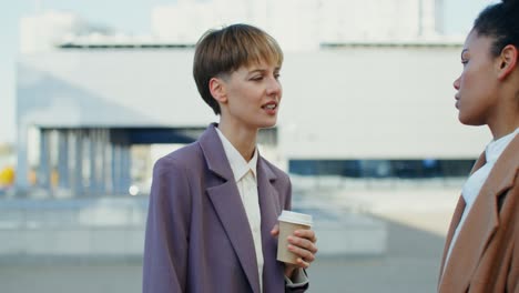 two women talking outdoors over coffee