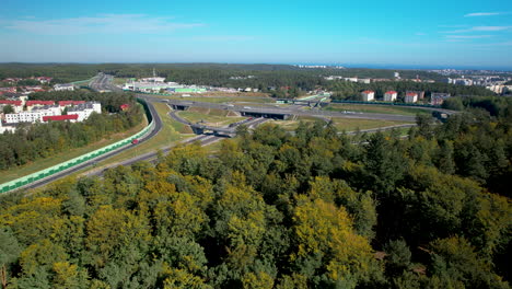 Large-highway-with-multiple-lanes,-ramps,-junctions-and-overpass-surrounded-by-a-lush-green-forest-in-Gdynia-Wielki-Kack-Poland