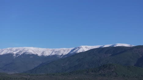 Filmaufnahmen-Mit-Einer-167-mm-Drohne-Im-Tiétar-Tal,-Wo-Wir-Das-Zentrale-Gebirgssystem-Der-Iberischen-Halbinsel-Sehen,-Die-Gipfel-Sind-Schneebedeckt-Und-Es-Gibt-Einen-Wunderschönen-Blauen-Himmel-In-Der-Provinz-Avila