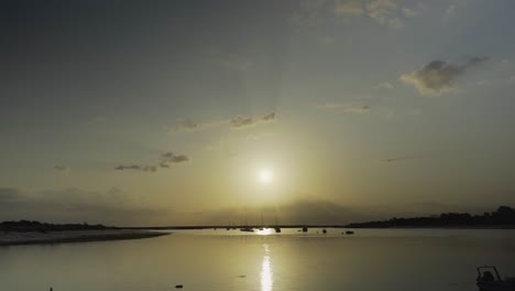 Flusssonne-Am-Morgen-Mit-Silhouettenbooten,-Die-In-Tavira-Portugal-Schwimmen