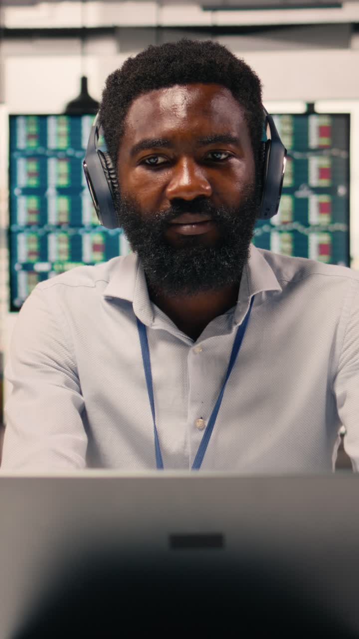 Vertical Video Black employee having fun with music wearing headphones in modern office