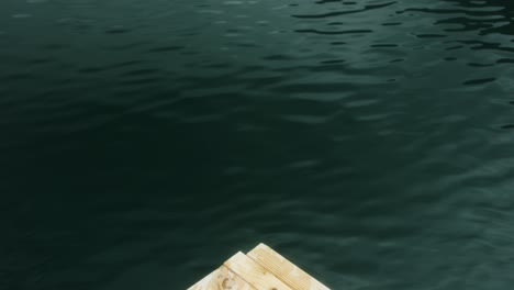 Mid-shot-of-tip-of-wooden-platform-on-body-of-water