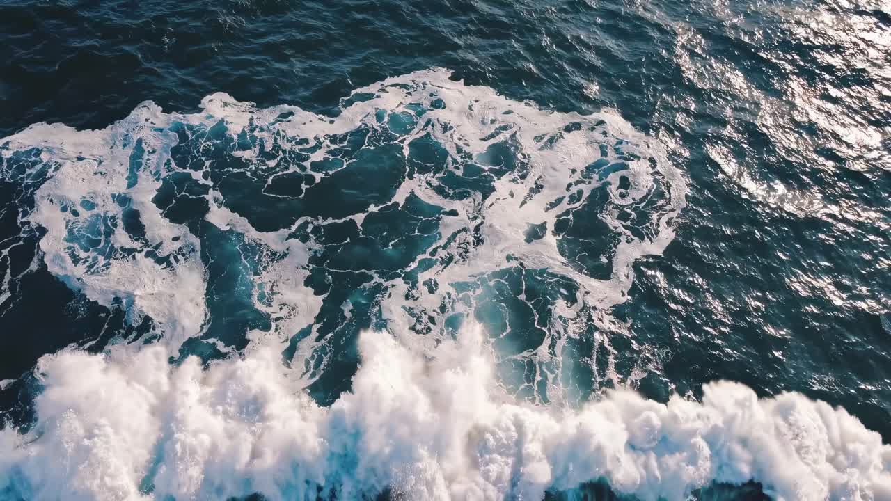 Aerial video captures swirling ocean waves from a high angle, showcasing the dynamic movement
