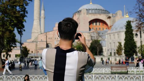 medium shot of young man taking photos of hagia sophia