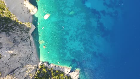 Orbiting-drone-shot-of-the-secluded-and-pristine-beach-of-Oasi,-located-in-the-village-of-Chania,-in-the-island-of-Crete-in-Greece