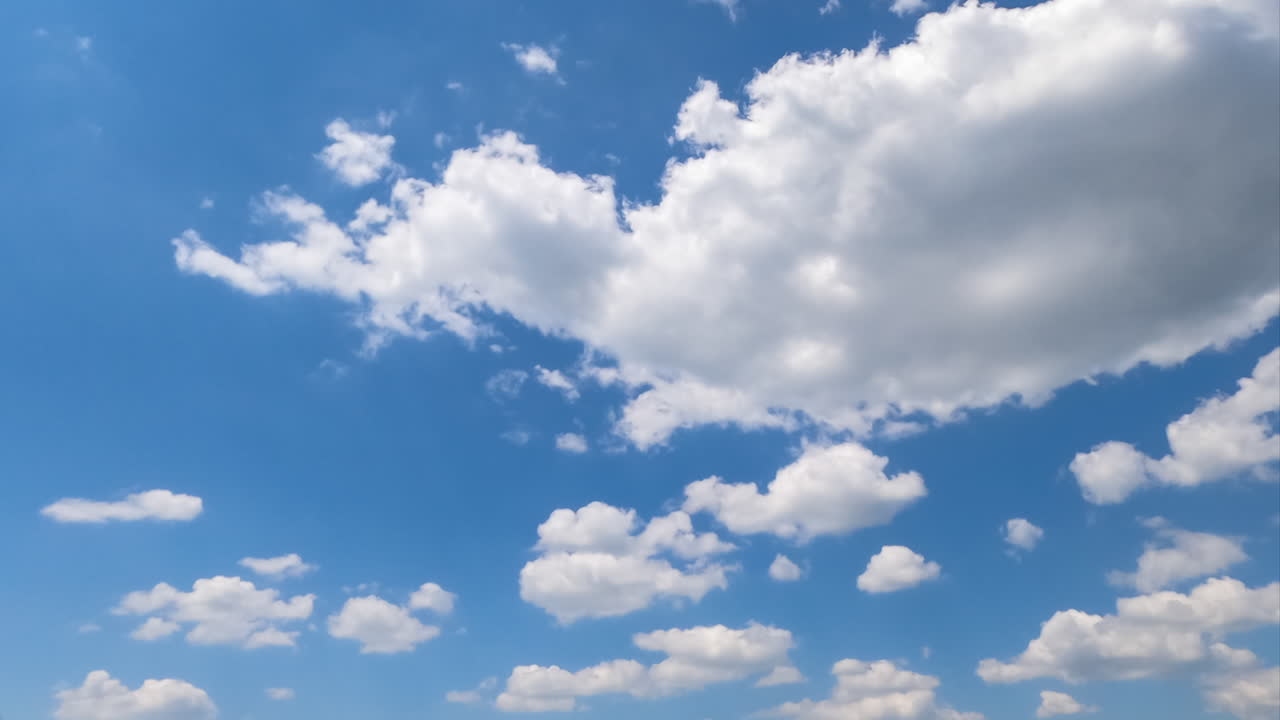 Soft beautiful clouds forming in the blue sky. Clouds flying quickly in the rays of sun. Timelapse.