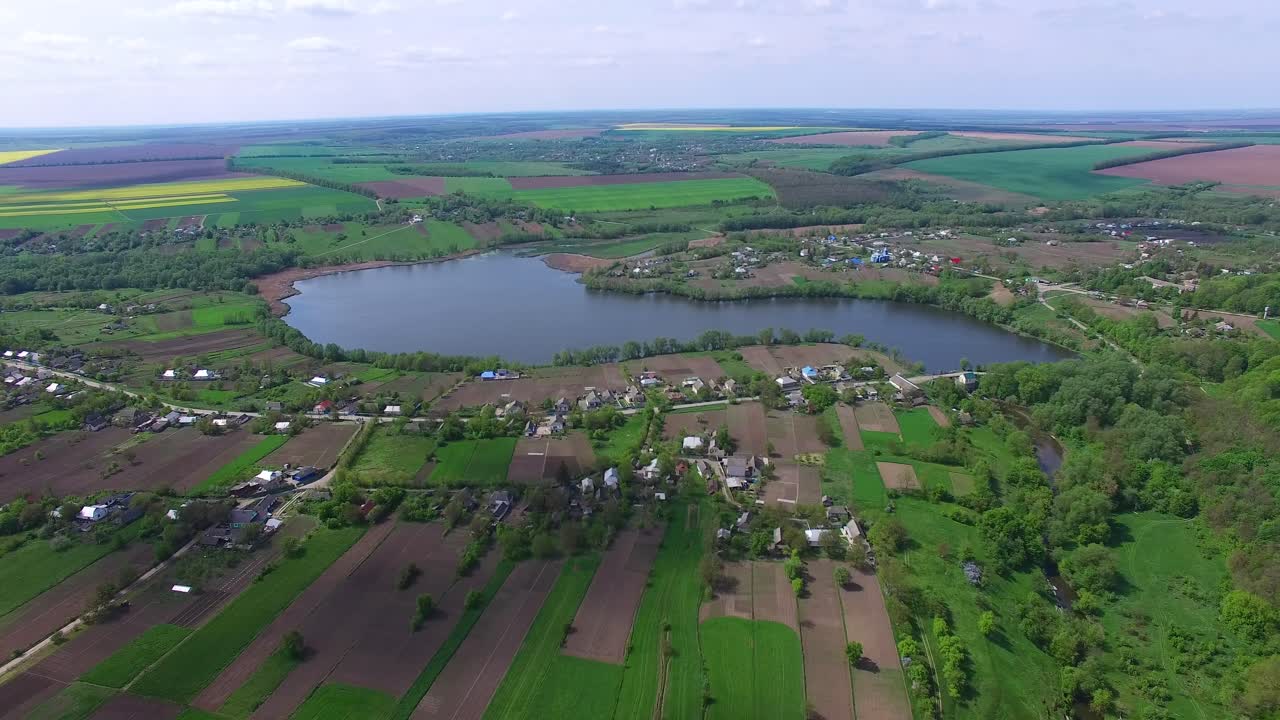 Village by the pond. Aerial view of small village houses near pond water