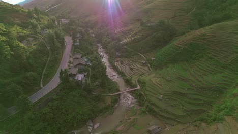 Sunset-aerial-view-of-Sa-Pa-nestled-in-Vietnam's-Hoàng-Liên-Son-Mountains,-highlighting-the-terraced-rice-fields-of-Muong-Hoa-Valley-and-the-seamless-harmony-of-agricultural-artistry-with-nature