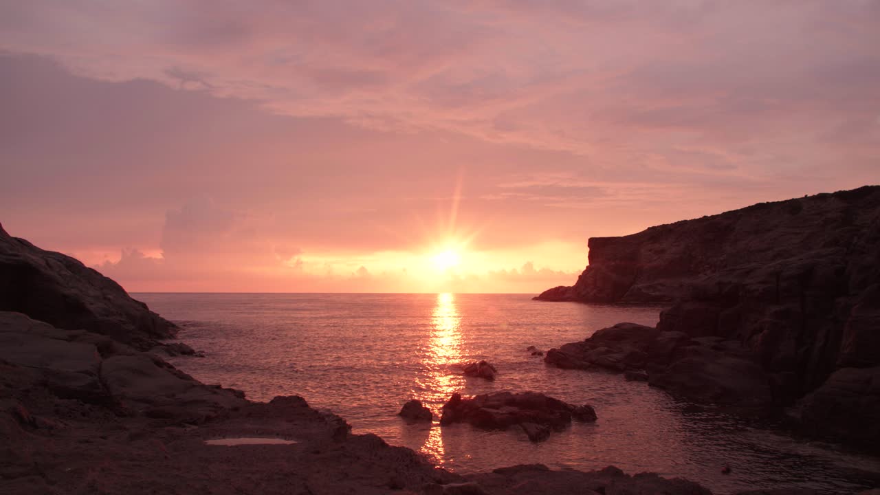 tramonto, mare che lava le rocce, nuvole rosa