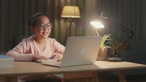 girl studying on laptop at night