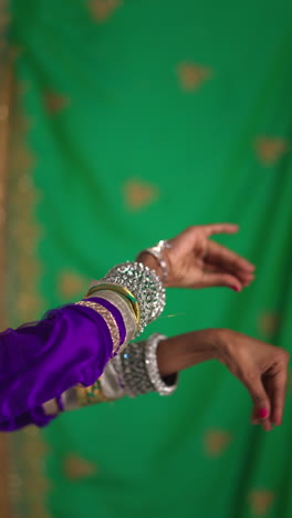 video vertical de primer plano en las manos de una bailarina de kathak que realiza un baile vestida con un vestido tradicional indio